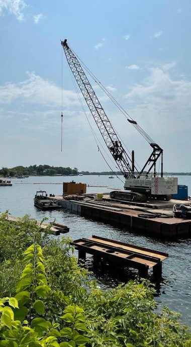 wayzata bay lakewalk under construction with crane on platform in the bay